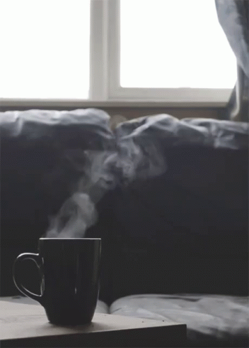 steam rising from a cup that is on a coffee table