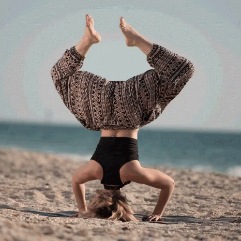 a woman in a skirt doing a handstand on her stomach