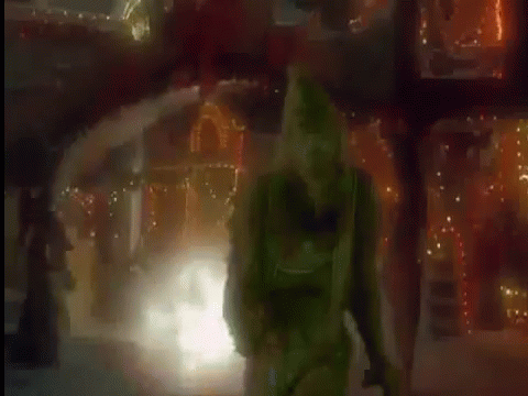 the woman in the green costume is walking through the snow