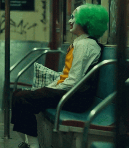 a man with a green wig sitting on a bus