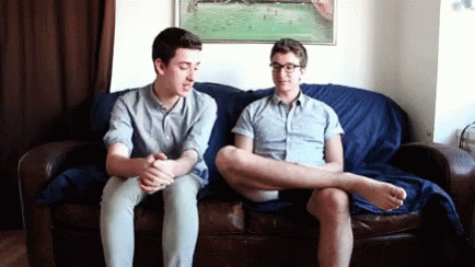 two men sitting on a couch in the living room