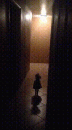 a person walks down a hallway in the dark