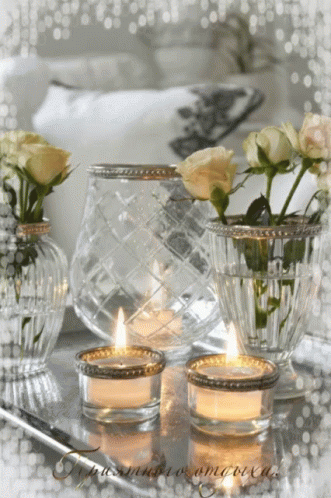 three vases with roses and a candle on a table