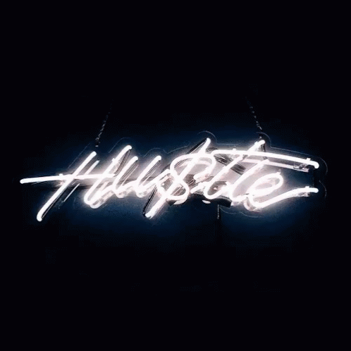 a neon sign saying hustle in the dark
