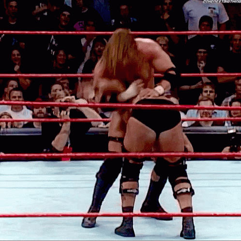 two people wrestling in an arena, all looking down