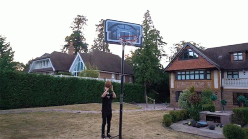 a man standing next to a basketball hoop