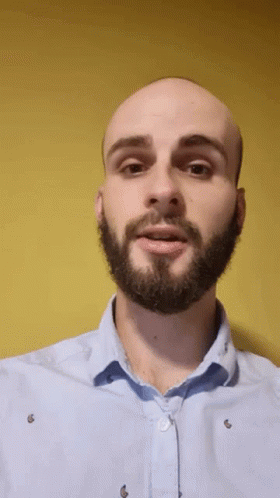 man in beige shirt with beard making funny face