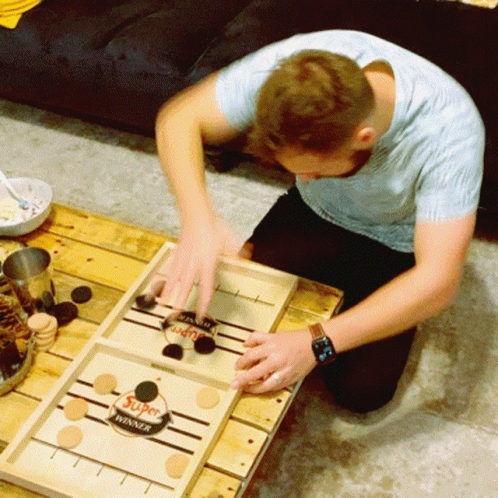a boy is playing a game with a blue tabletop