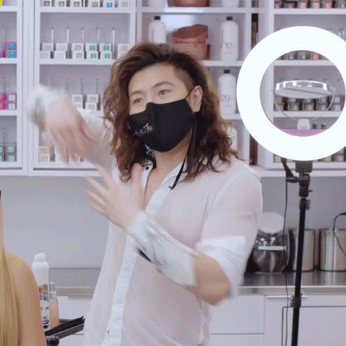 a person wearing a surgical mask standing in front of a counter
