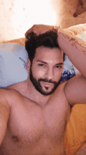 a man is sitting in bed wearing a beard