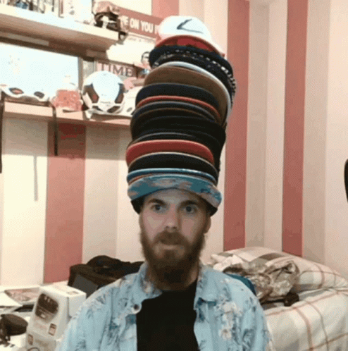 a man wearing a hat full of caps