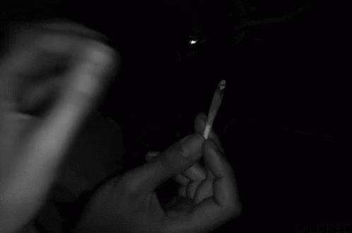 two hands holding an electronic cigarette in the dark