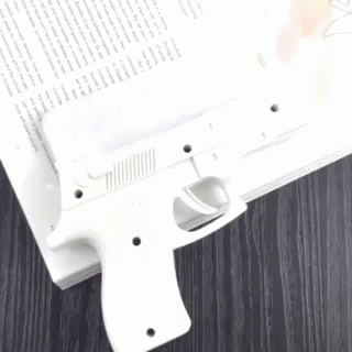 a gun that is next to an opened book
