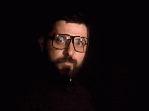 a man with glasses is in the dark