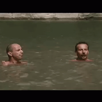 two bald men swimming in the water and talking
