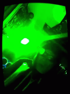 a person with green light in a black room
