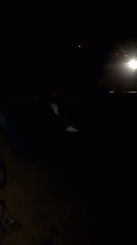 an empty parking meter at night on a dark street