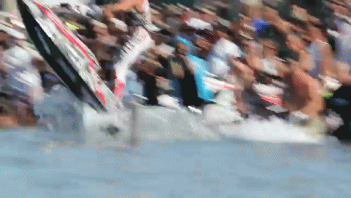 a crowd of people watching a man with surfboards
