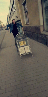 a man standing on the sidewalk with a stroller