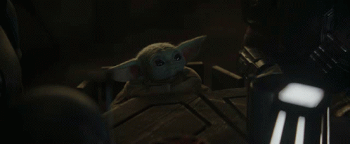 a baby yoda character is sitting in a chair