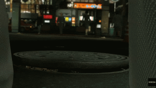 a manhole cover in the middle of the floor at night