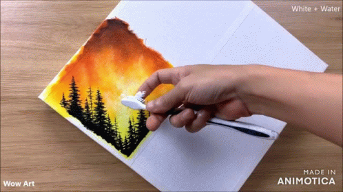 a hand is painting a landscape with blue and green