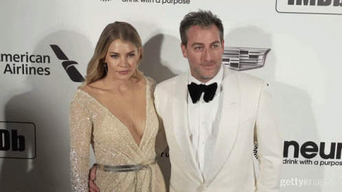 a man and a woman standing on a red carpet