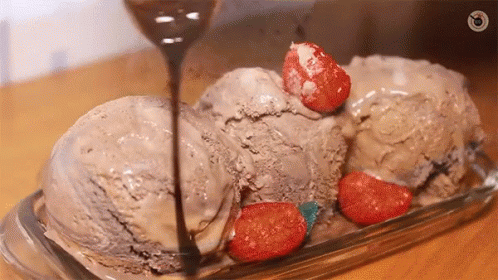 three scoops of ice cream sit in a clear dish with a spoon