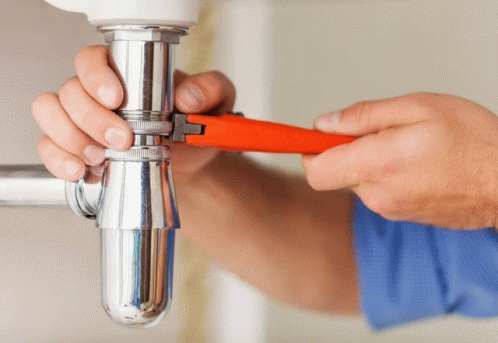 a man holding onto a handle to fix a water faucet