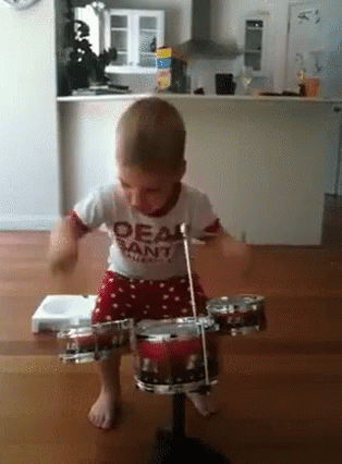 there is a small toddler that is playing with a toy drum
