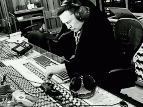 a man sitting in front of sound equipment at a desk