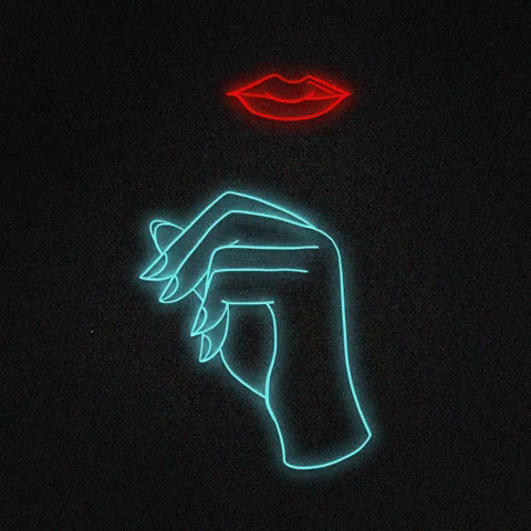 a man's hand holding soing with a lit up woman's face and lips in the background