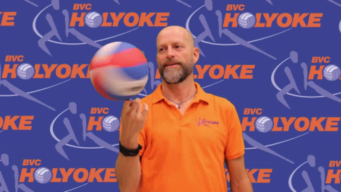 a person posing for a picture holding a ball
