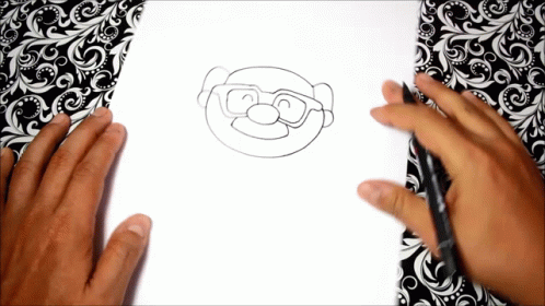 someone drawing a picture on paper that looks like the simpsons with sunglasses