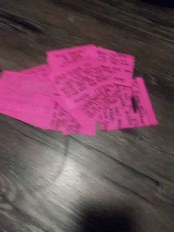 a pair of pink paper tags on a wooden floor