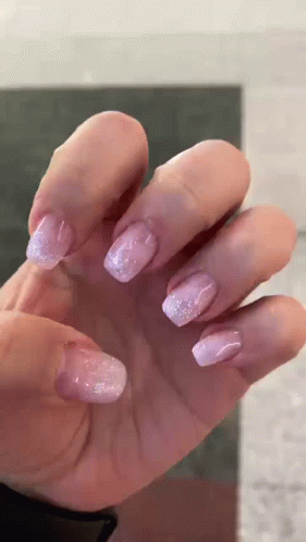 purple manies on someones fingers with pink flecky fingernails