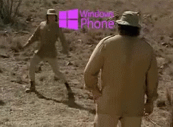 two men in hats and clothes with the windows phone logo behind them