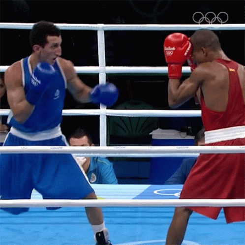 two boxers during a boxing match in front of a referee