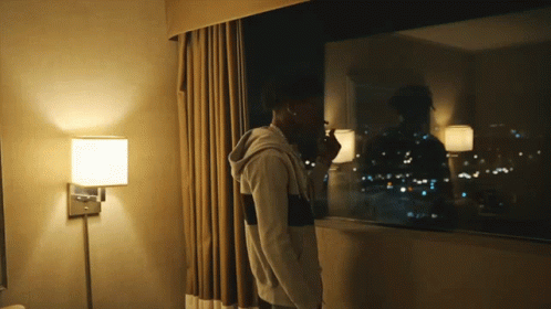 person in room looking at city lights from large window