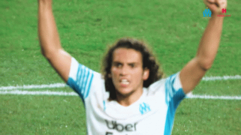 a man raising his arms in triumph on a soccer field