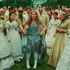 several people standing in long dresses wearing historical garb