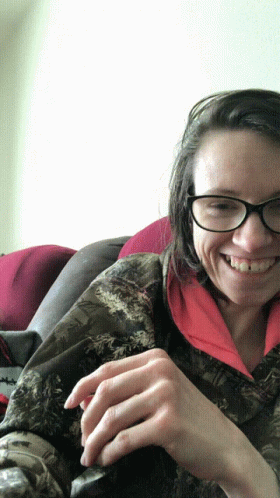woman with glasses and holding a cat sitting on her lap