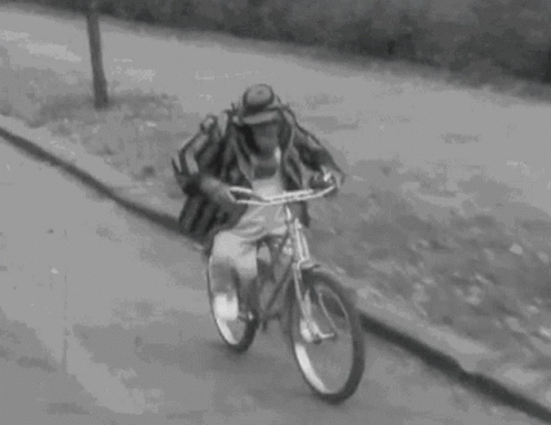 a man riding on a bicycle down a hill