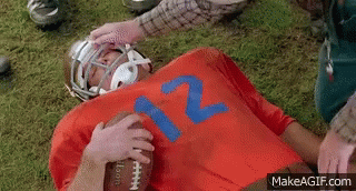 three football players with helmets laying in the grass