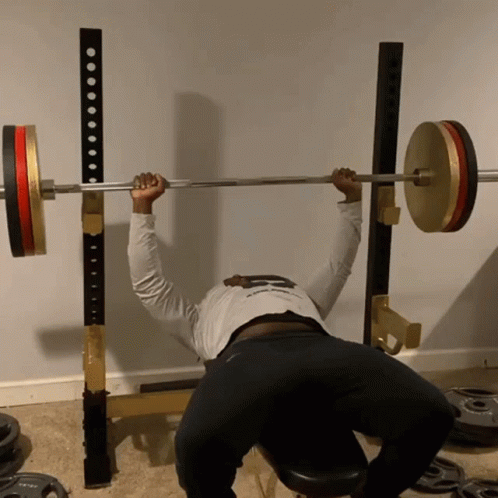 a person squats on a bench as he is doing a barbell squat