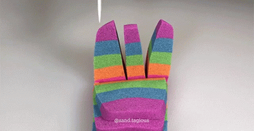 a close up of someones hands in rainbow striped mitts