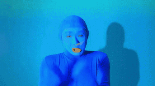 a man in orange with soing blue on his nose