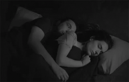 two young women sleeping together on a bed