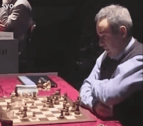 older man at table with giant chess game