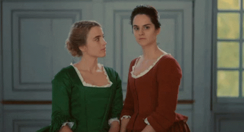 two people dressed in green talking on the same dress